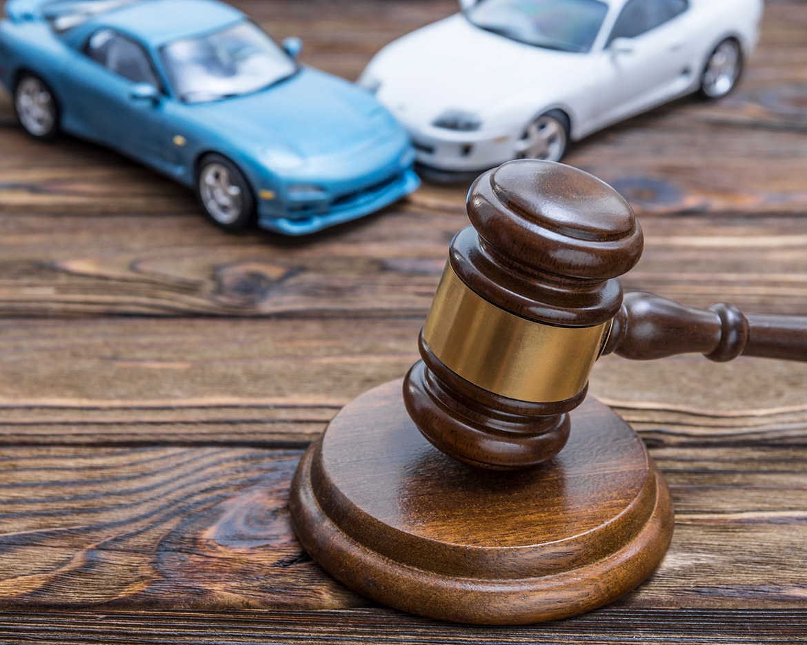 gavel of a judge with two cars hitting in background