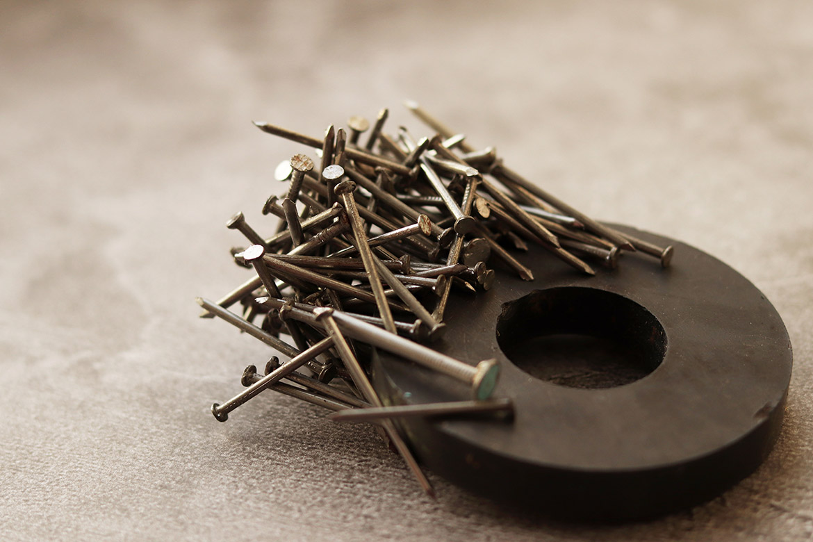 pile of thin metal nails on a magnet