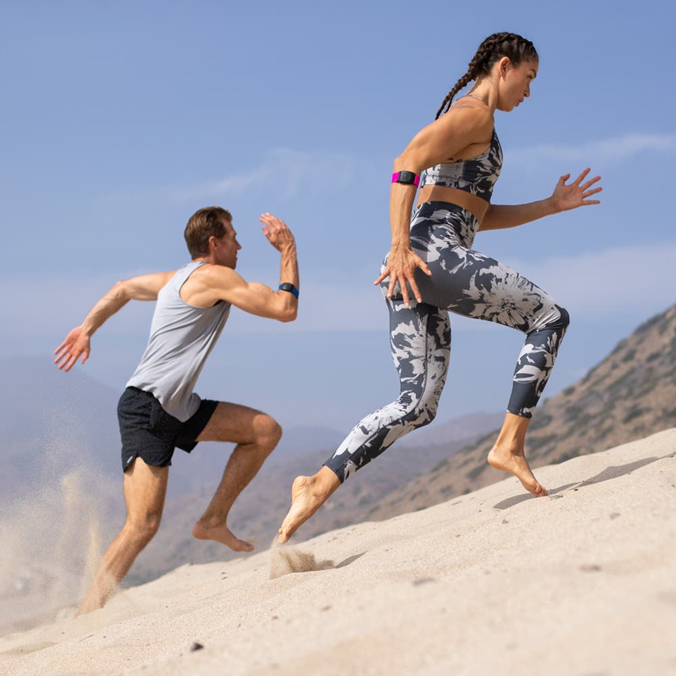 man and woman running with heart rate monitor armband